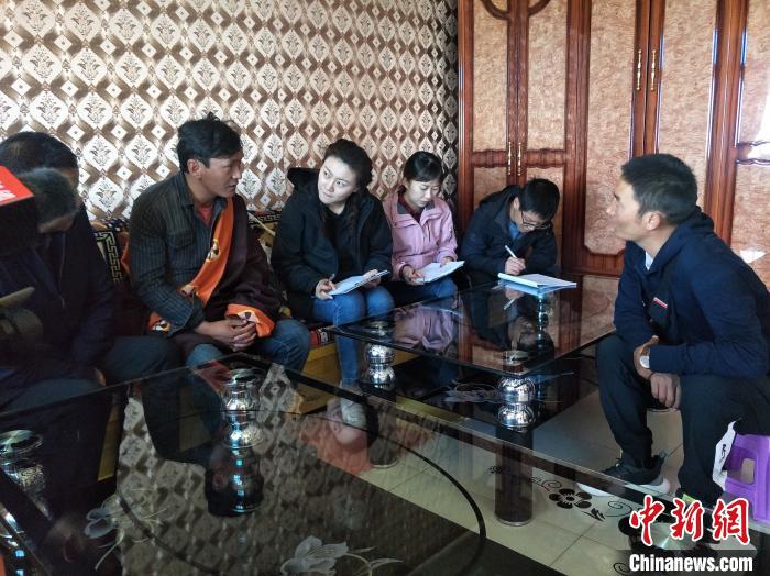 圖為調(diào)查組工作人員正在入戶調(diào)查。　祁增蓓 攝