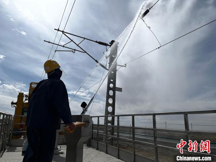 圖為高壓水槍的水柱沖洗絕緣子串?！「邌⒑?攝