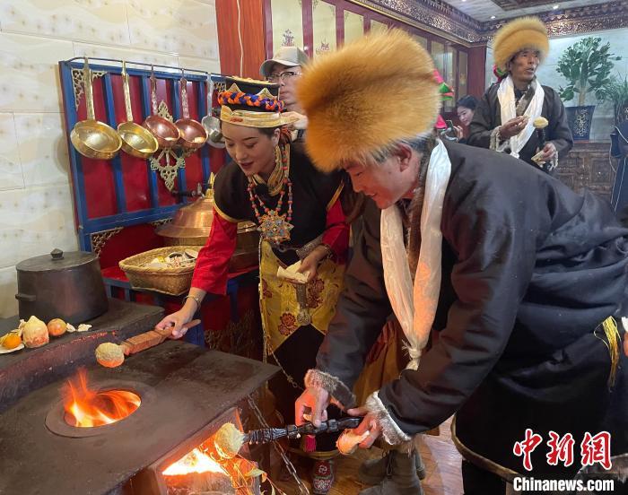 圖為人們?cè)诨鹕峡竟?jié)日美食“結(jié)達(dá)”?！∪轿木?攝