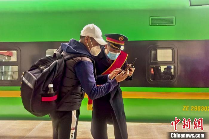 圖為日喀則火車(chē)站工作人員服務(wù)乘客?！《飞降?攝