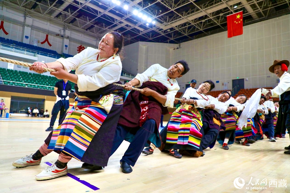 身著民族服裝的農(nóng)牧民選手在拔河比賽現(xiàn)場。